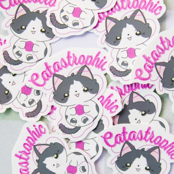 Several stickers of a cat playing with a yarn ball with the text catastrophic above it.
