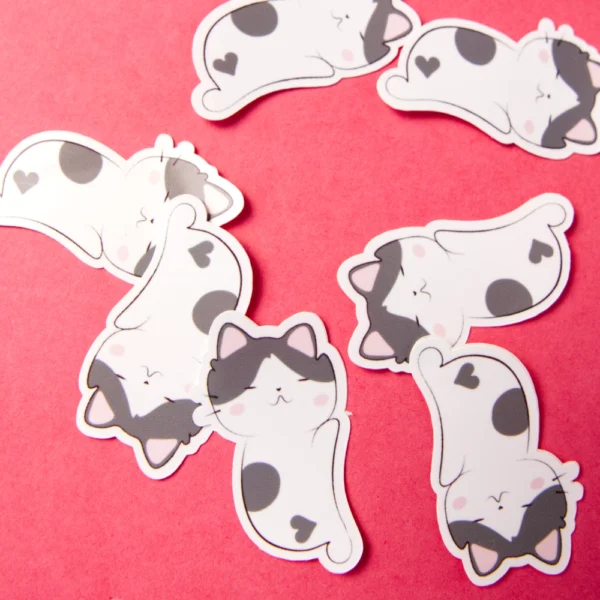Several stickers of a sleeping cat with a heart shaped spot in its butt.