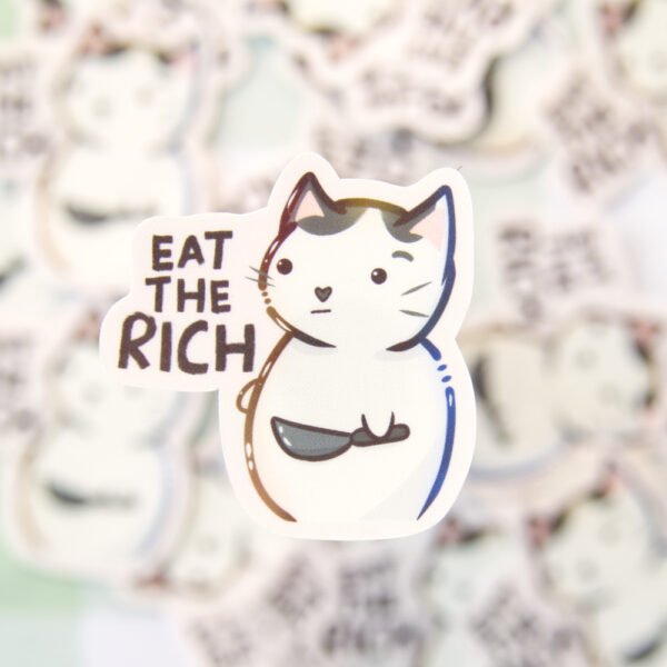 A sticker of a cat holding a knife with the text eat the rich.