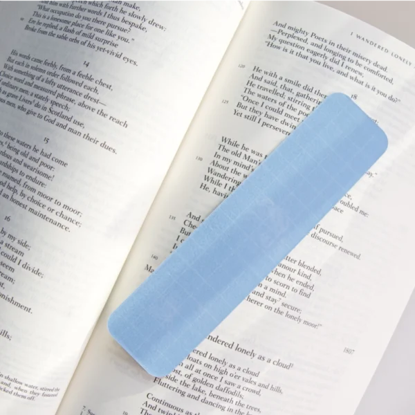 The back of a blue bookmark that is placed on top over an open book.