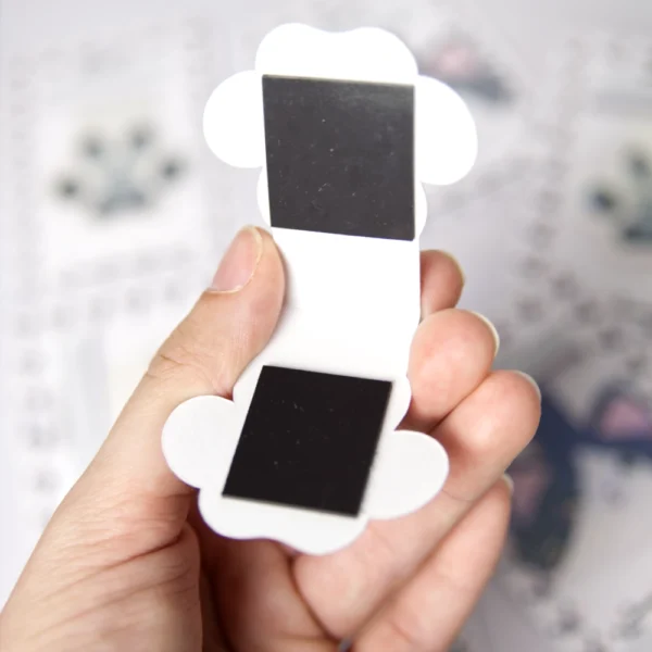 Open paw-shaped magnetic bookmark with a colorful, geometric design. The magnets are visible.