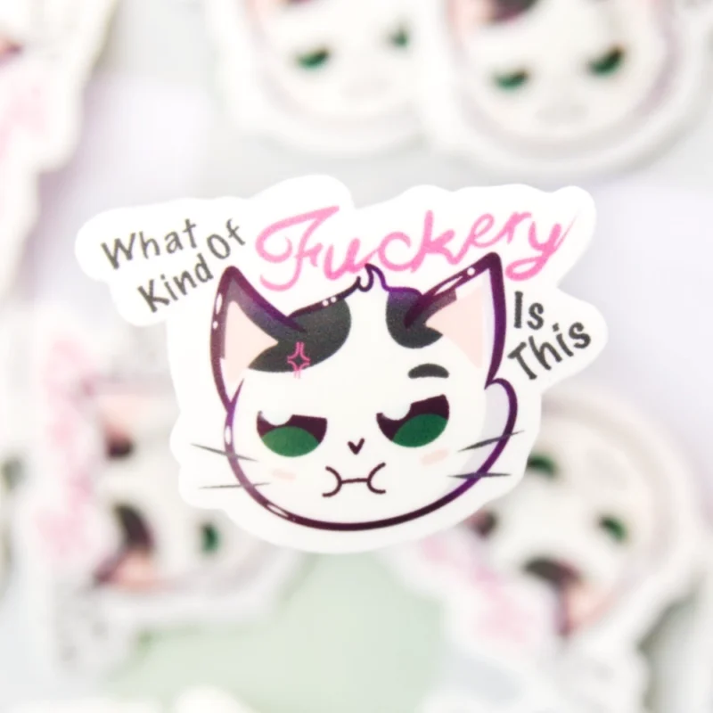 A sticker of a cat not looking content with the words what kind of fuckery is this.