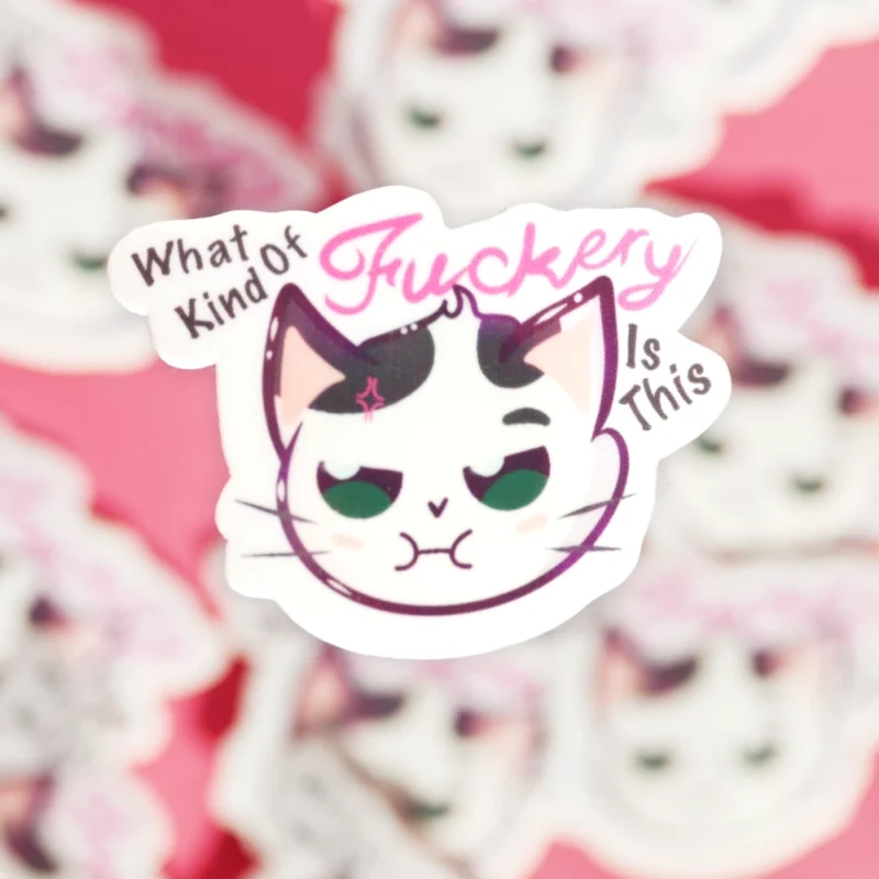 A sticker of a cat not looking content with the words what kind of fuckery is this.