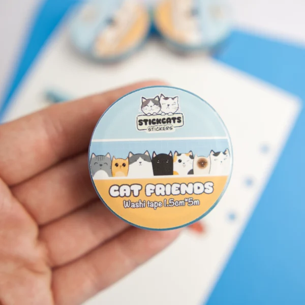 A clear product photo of the packaging of a washi tape. It's blue and orange and decorated with cats.