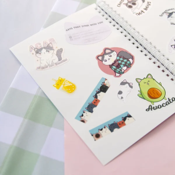 A sticker book laying open faced with various cat stickers displayed.